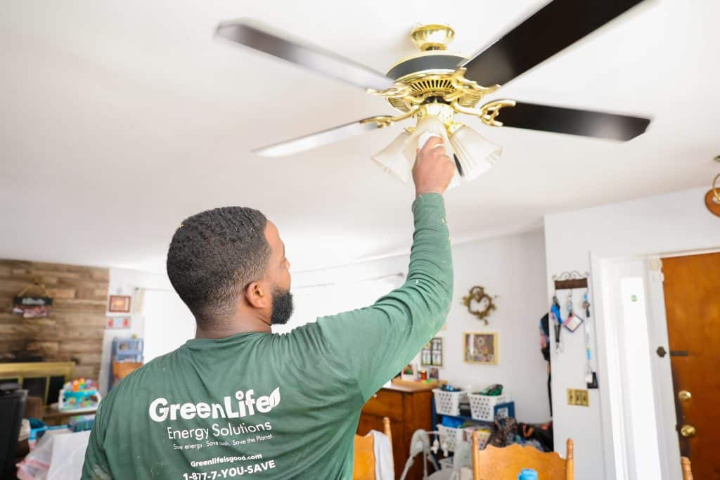 GreenLife employee changing a light bulb