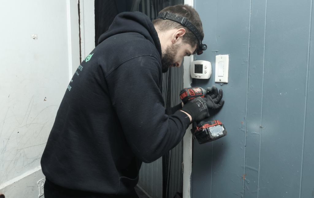 GreenLife auditor checking a thermostat