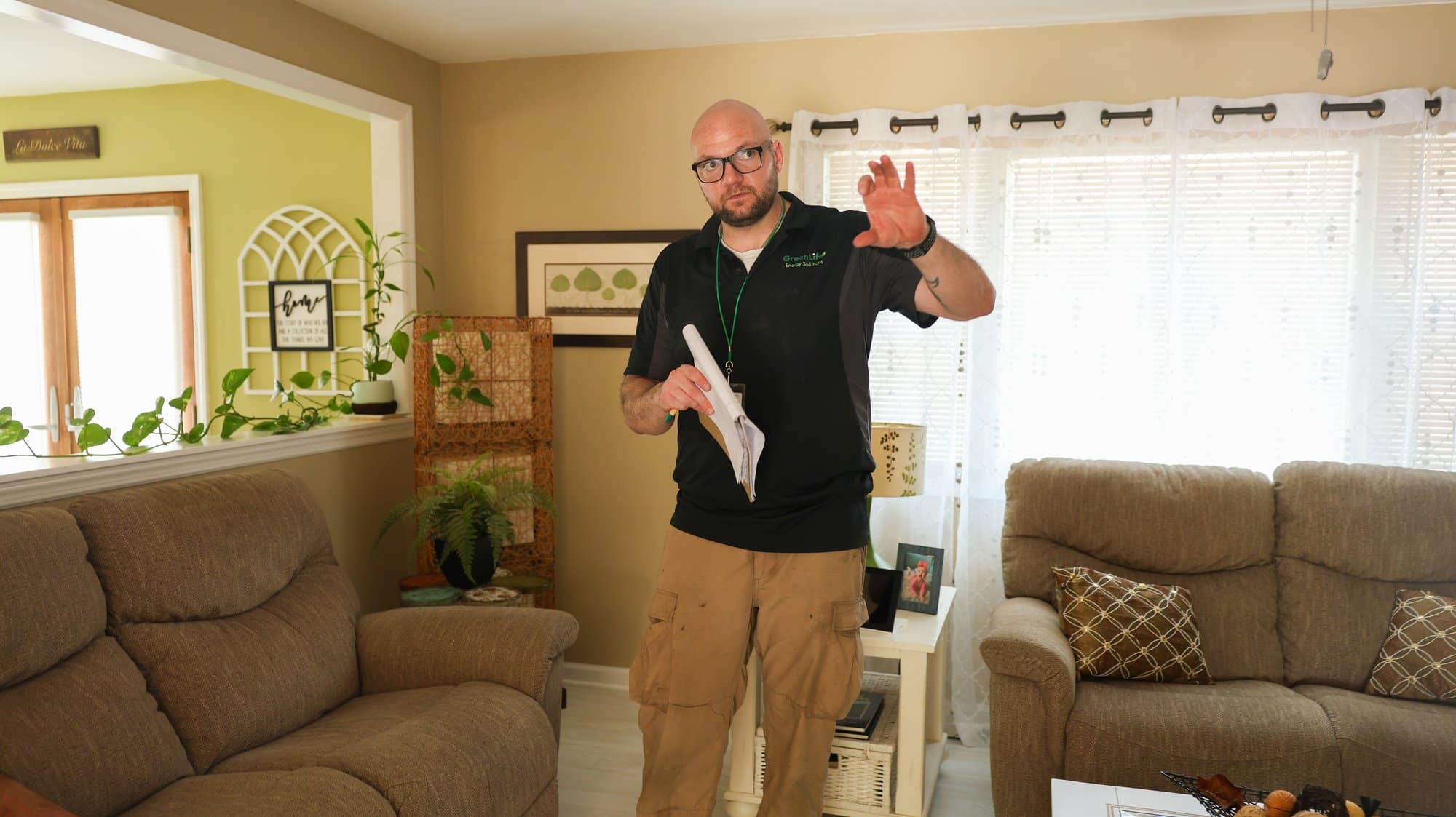 GreenLife Energy Solutions technician explaining a home energy assessment in a living room
