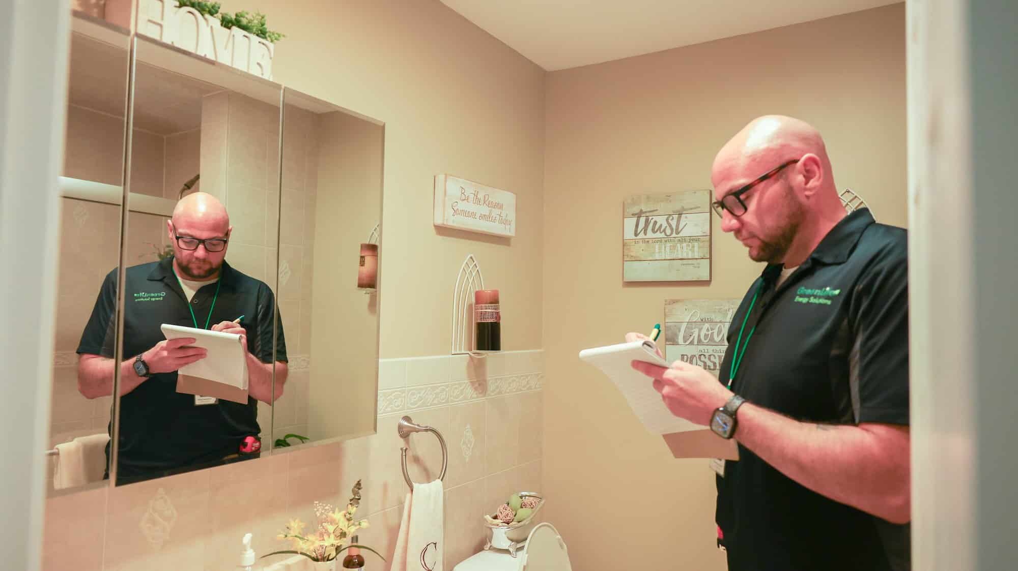 GreenLife technician taking notes during an in-home energy assessment
