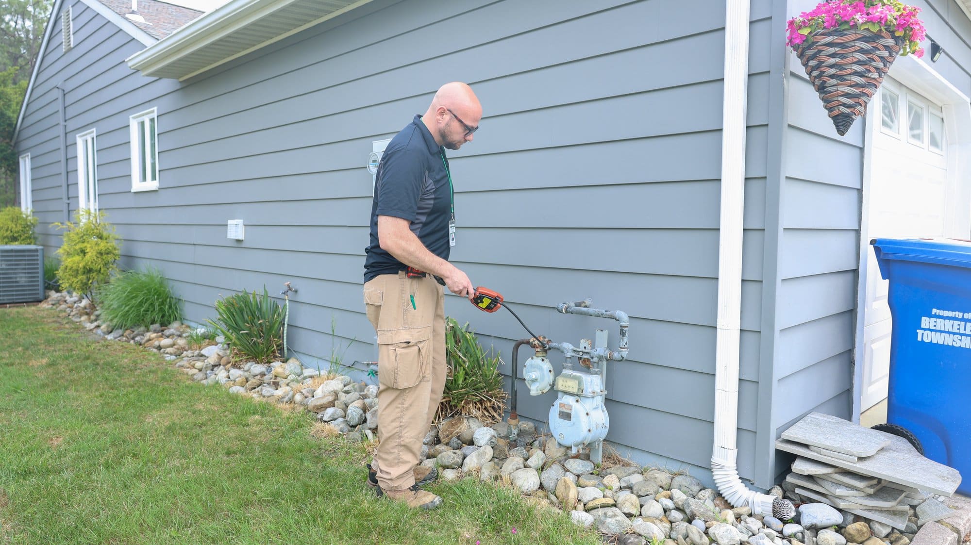 GreenLife technician checking outdoor equipment during a home energy assessment